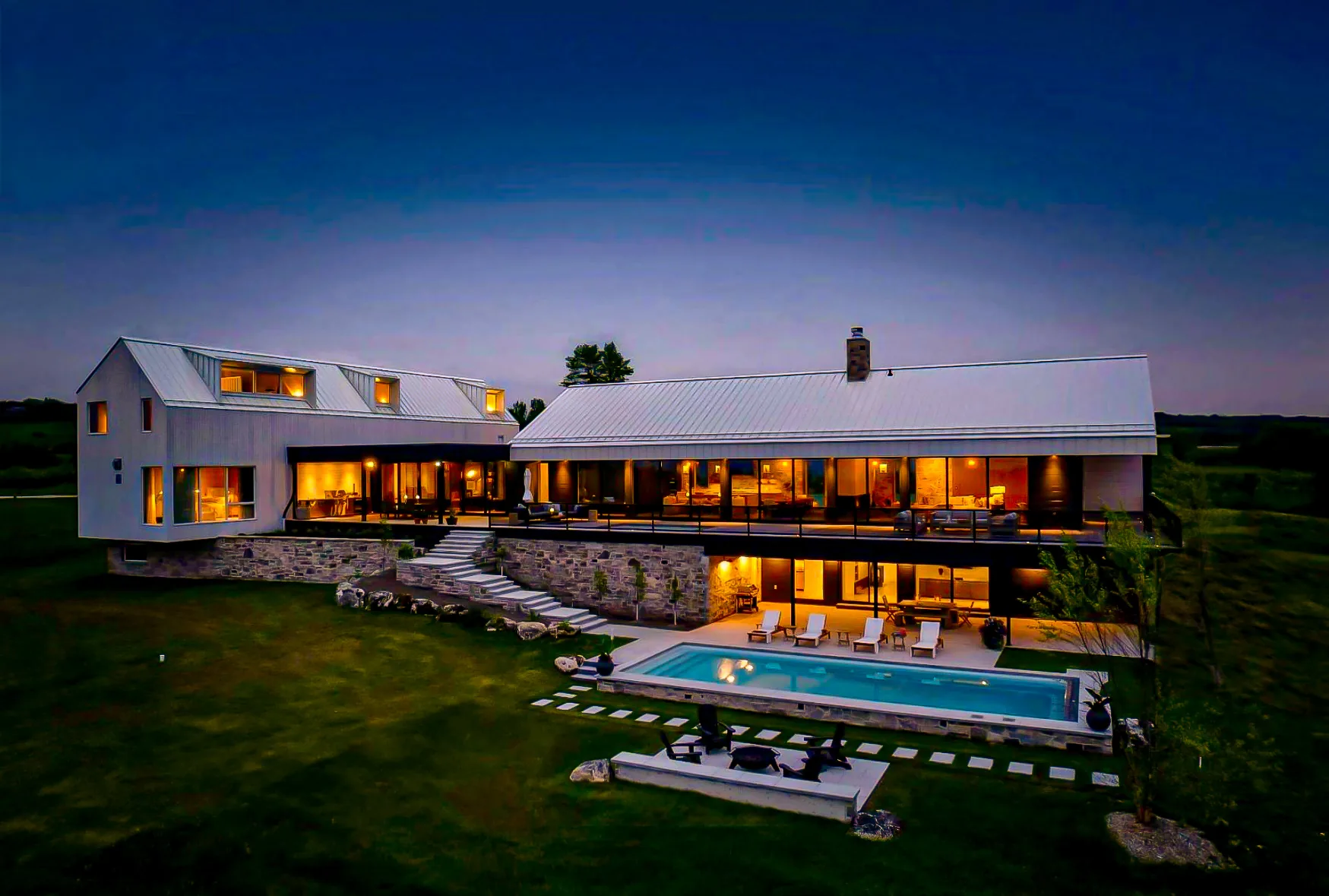 Modern Lakeside Overlook by Headwaters Landscape Design & Construction — twilight estate pool and residence view